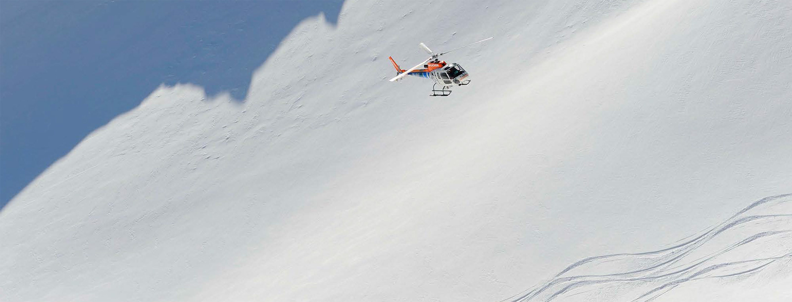 Helicopter flying over a ski run