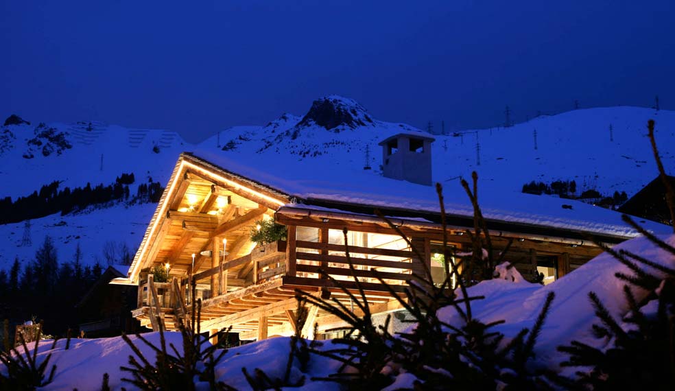 A luxury chalet lit up as the night draws in